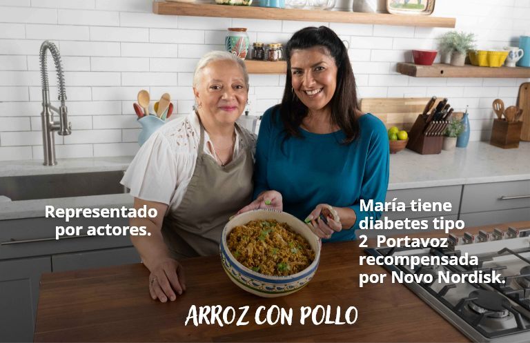 Imagen en miniatura con el signo de video de María y su abuela en la cocina mostrando un plato que prepararon 